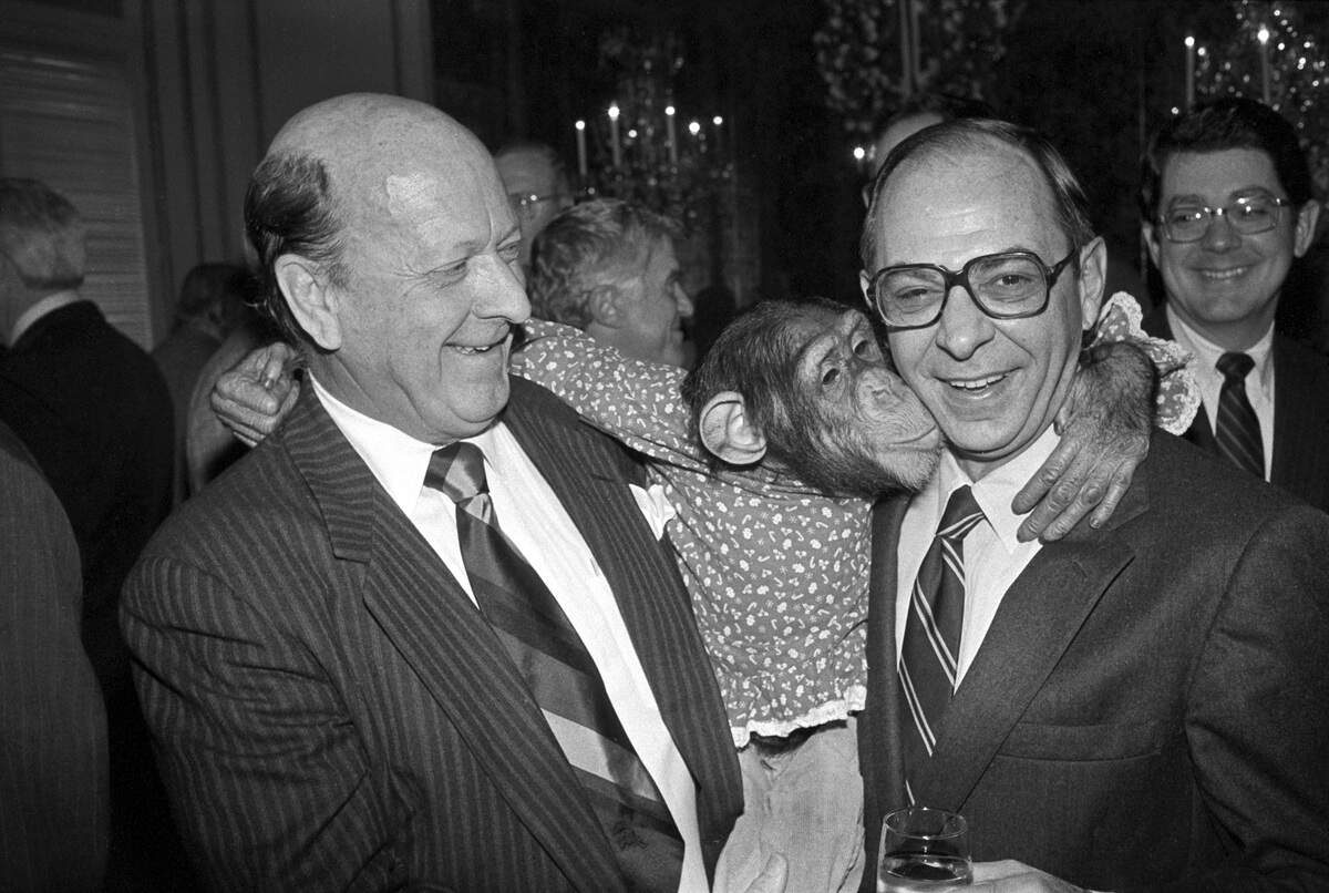Earl Parker, left, of the Fort Worth Exchange Club, watches Deena the chimp give TCU Chancellor William Tucker a kiss during an Exchange Club luncheon to raise money for the Goodfellows Fund, 1984. 