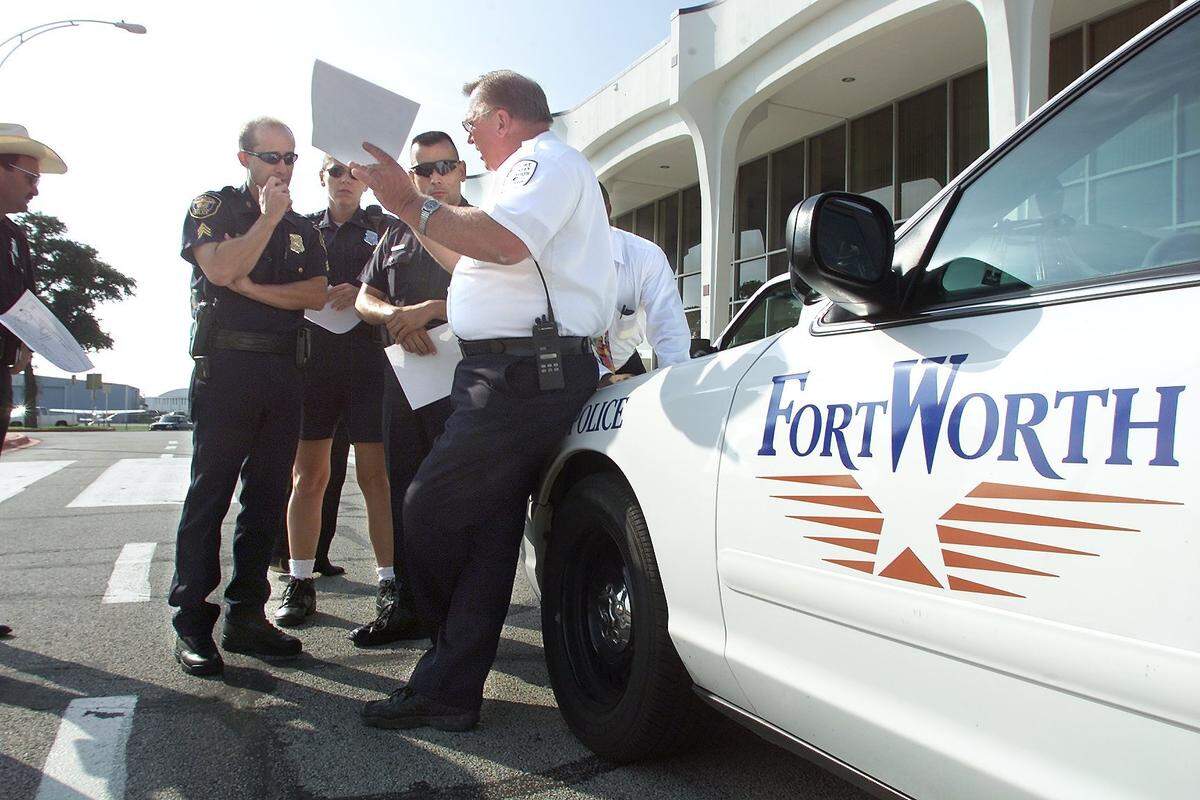 Fort Worth Aviation security supervisor Dennis Rotzoll, right, helps direct Fort Worth police to secure the perimeter of Meacham International Airport on the morning of Sept. 11, 2001.