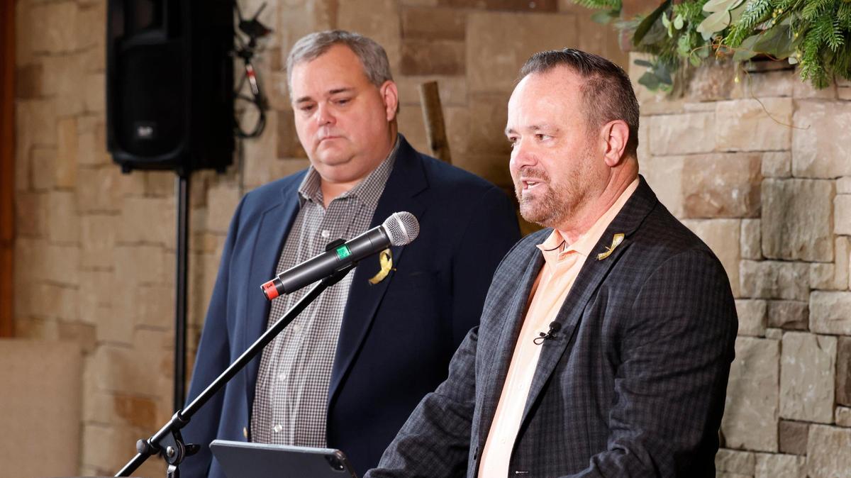 Brian Black, president of Heritage HOA, listens as Cary Moon, chairman Heritage Legal Task Force, announces that the association has joined a lawsuit against five Keller ISD board members.