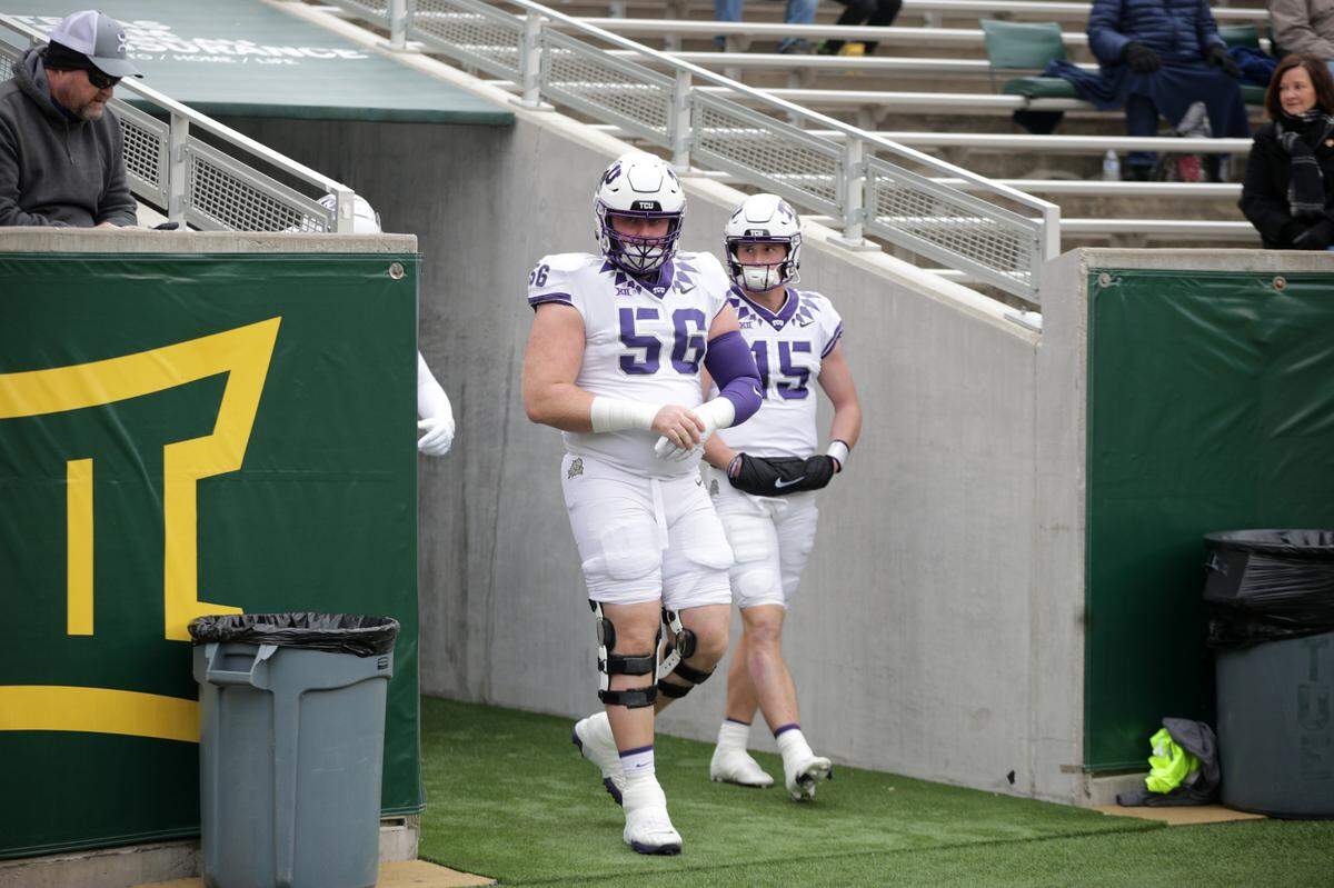 TCU offensive lineman Alan Ali and TCU quarterback Max Duggan walk onto the field before their game against Baylor at McLane Stadium in Waco on Saturday, Nov. 19, 2022.