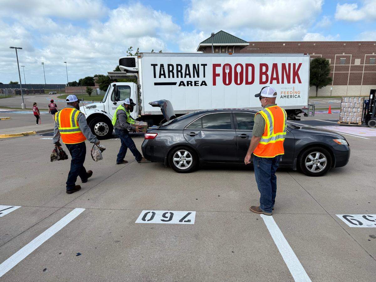 Weatherford electeic company employees work together to load a Park County resident’s car with food.