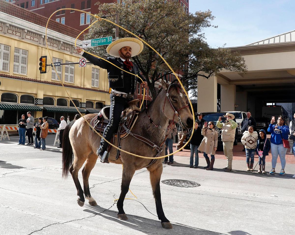 A trick roper entertains on Houston Street during the 2023 Fort Worth Stock Show and Rodeo parade in downtown Fort Worth on Saturday.