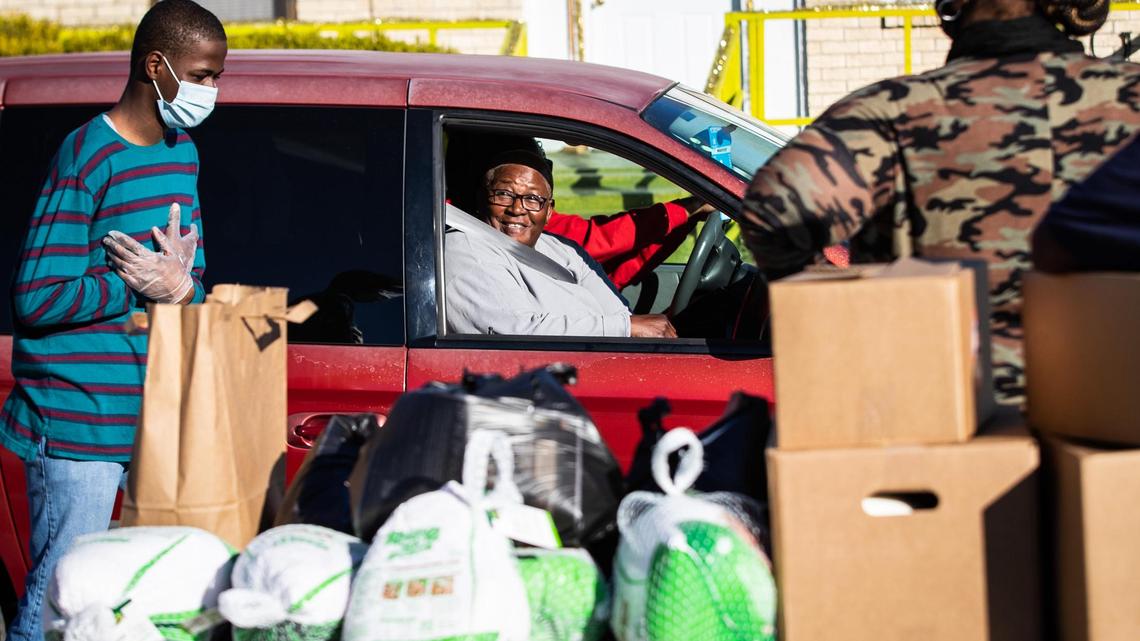 Kathy Anderson thanks volunteers with Tarrant Area Food Bank who loaded food into her car at a holiday food distribution Monday, Dec. 21, 2020, in Historic Southside neighborhood in Fort Worth.