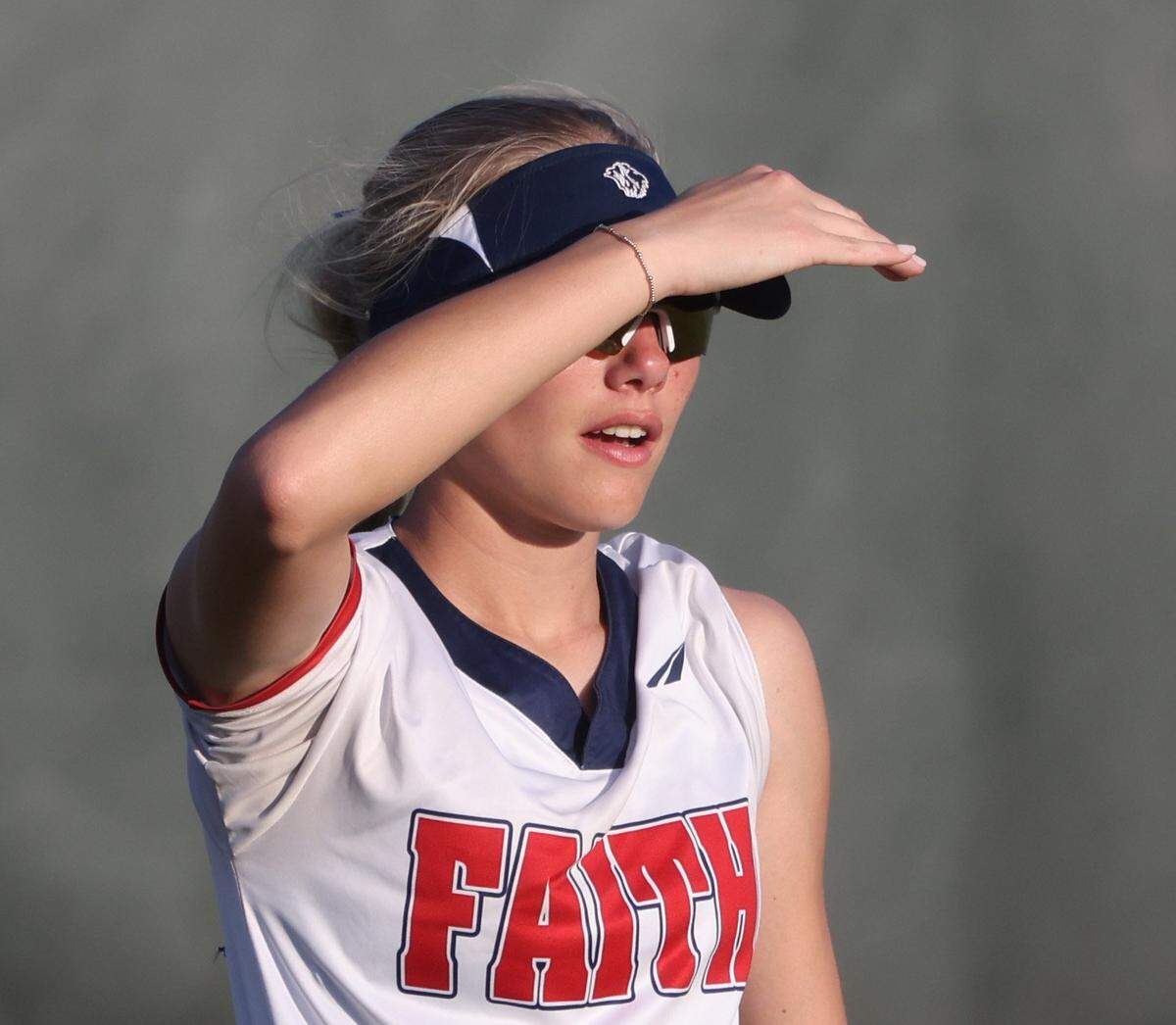 Grapevine Faith's Michaela Hamilton shields her face from the direct sun in center field during a softball game at Oak Grove Park in Grapevine, Tx. Tuesday, March 31, 2026