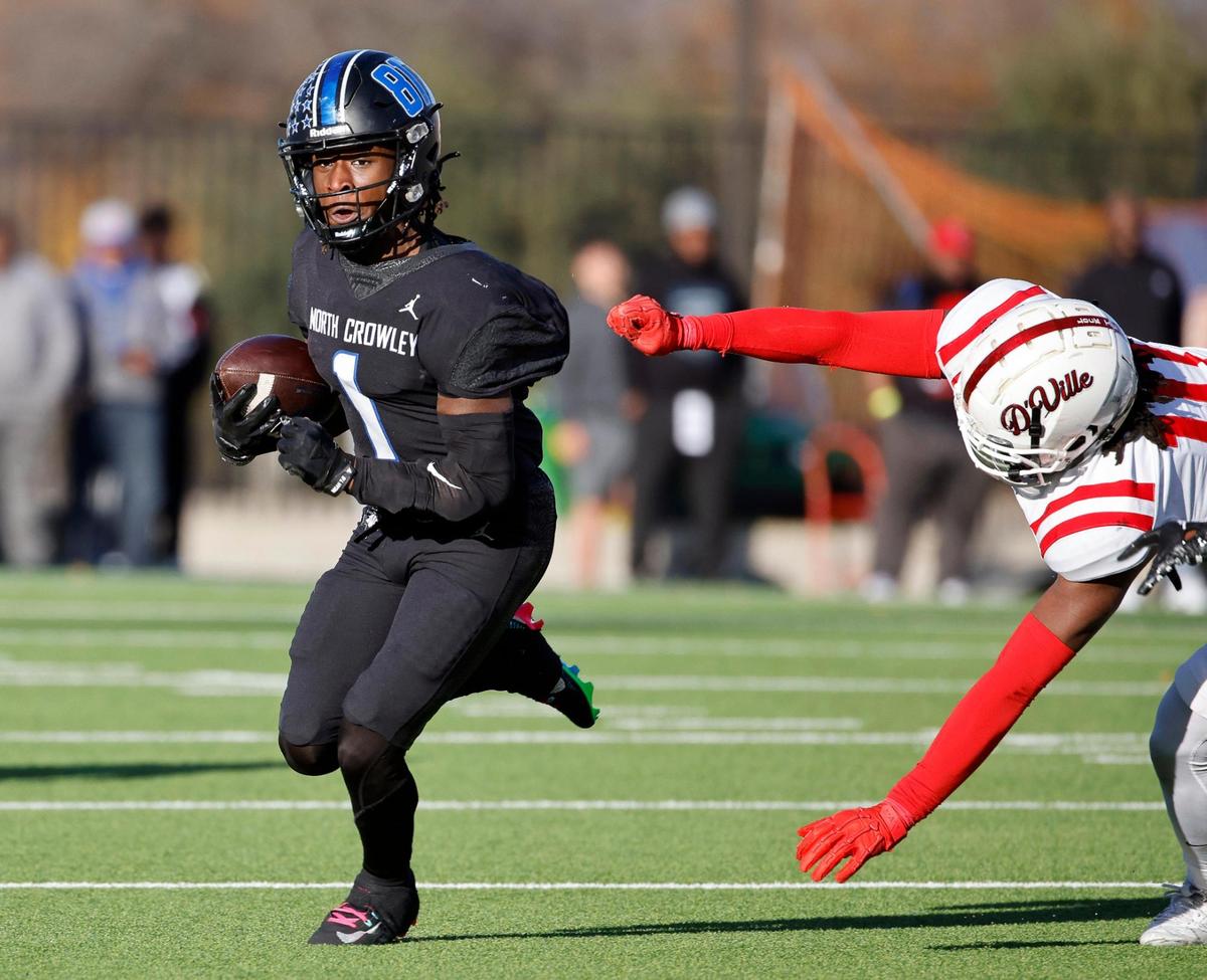 North Crowley running back Cornelius Warren (1) out runs the grab by Duncanville defensive end Kevin Ford (10) during the first half of a UIL Conference 6A Division I state semifinal football playoff game at Mesquite Memorial Stadium in Mesquite, Texas, Saturday, Dec. 09, 2023. Duncanville led North Crowley 24-0 at the half.