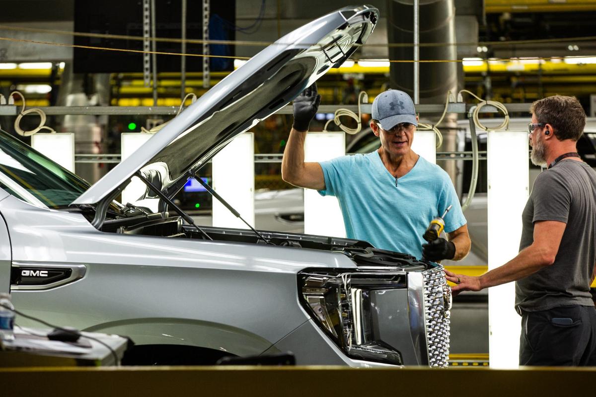 GM employee Rod Beane speaks with a worker at the General Motors Assembly Plant in Arlington on Friday, July 26.