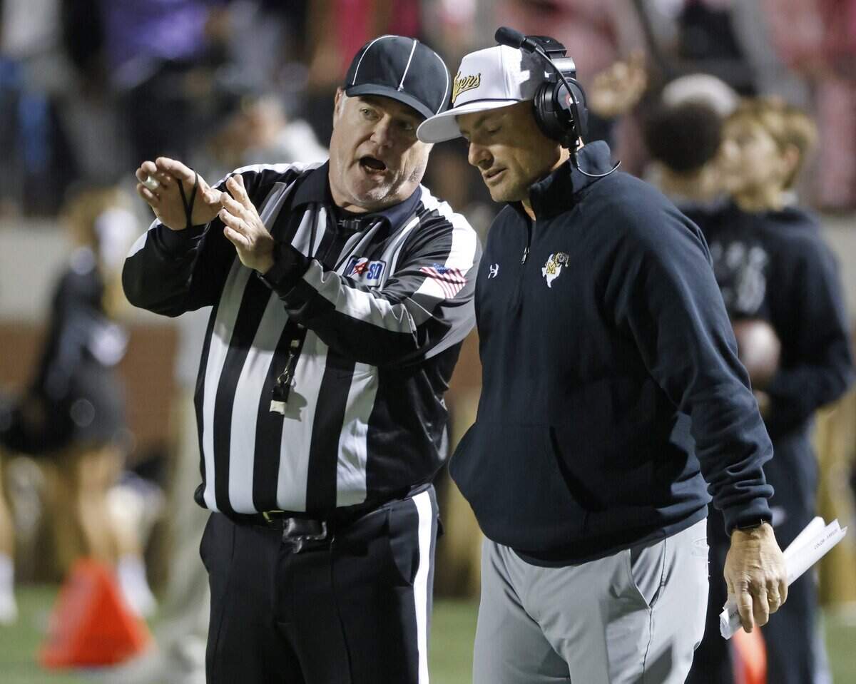 Mansfield head coach Greg George gets an explanation from head linesman Drew Brock during the first half of a UIL football game between North Crowley and Mansfield at Vernon Newsom Stadium in Mansfield, Texas, Thursday, October, 30, 2025.