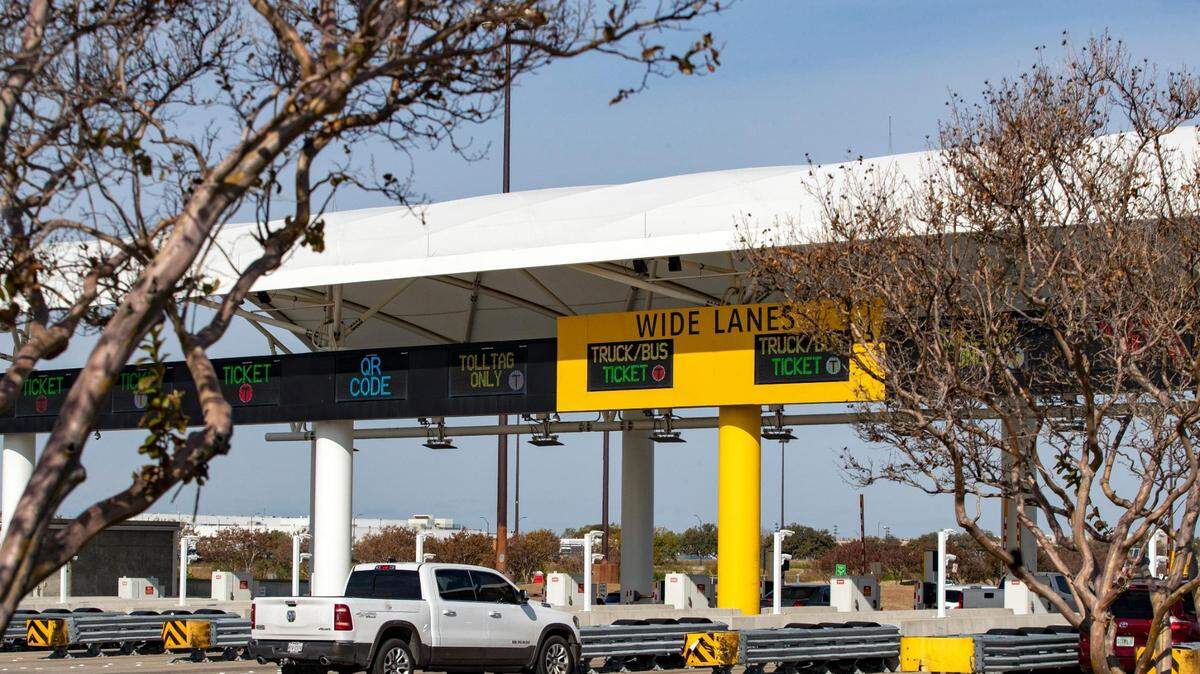 Cars drive through the toll booth at the Dallas Fort Worth International Airport on Friday, Nov. 18, 2022.