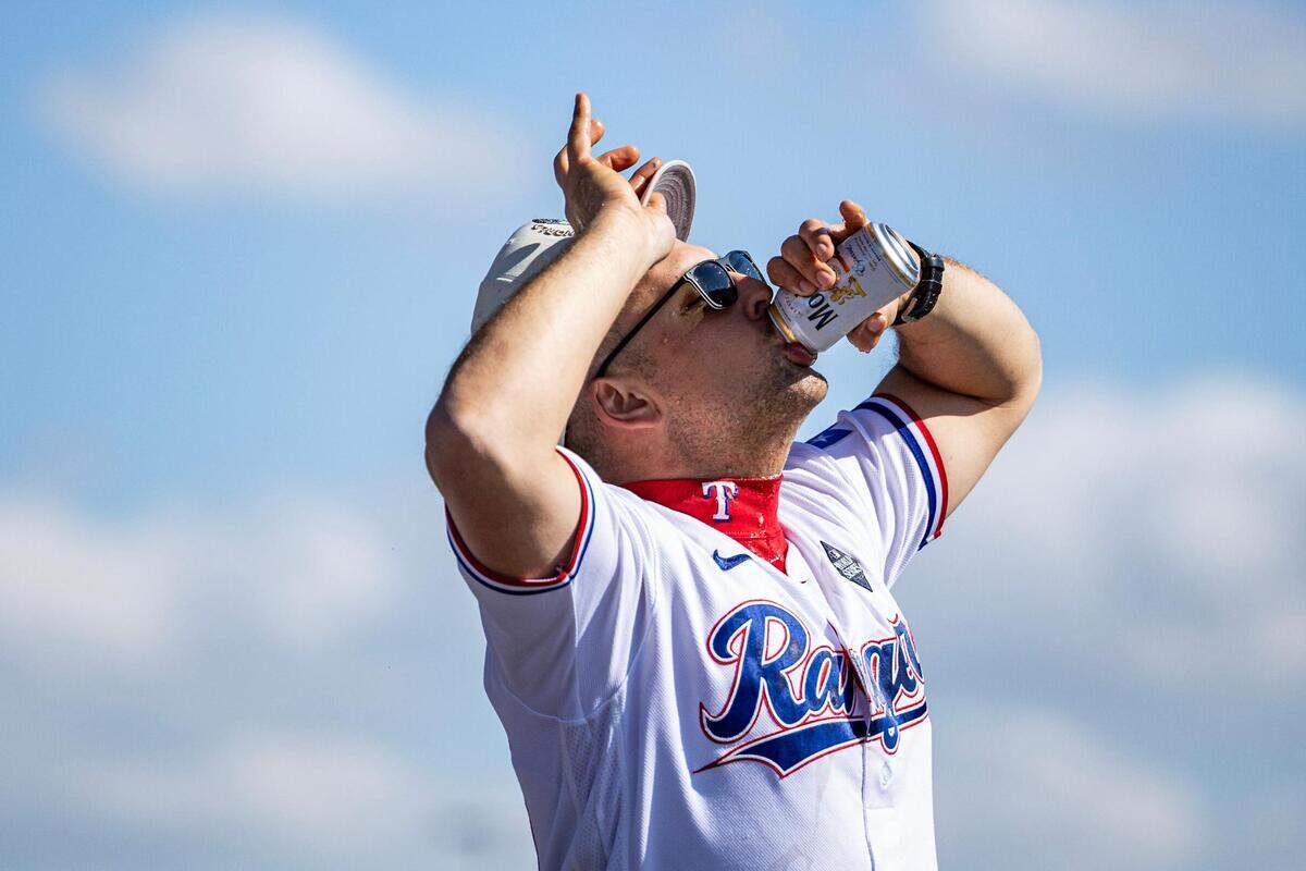 Rangers first baseman Nathaniel Lowe drinks a beer and celebrates with the crowd for the World Series Parade in front of Globe Life Field in Arlington on Friday, Nov. 3, 2023.