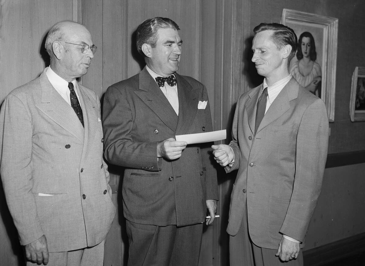 Kelly Fearing, far right, receives a first place Fort Worth Art Association award check from E. J. Henderson and O. P. Newberry, left, in 1945.