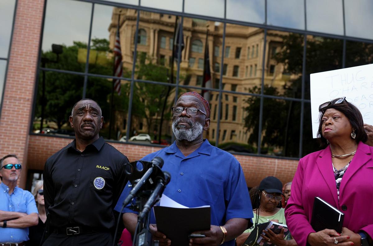 Michael Bell of the Unity in the Community Coalition, center, speaks during a press conference on Thursday, April 18, 2024, concerning Tarrant County Judge Tim O’Hare’s comments to Commissioner Alisa Simmons on Tuesday. Numerous people gathered in front of the Tarrant County Administration building to speak out against O’Hare.