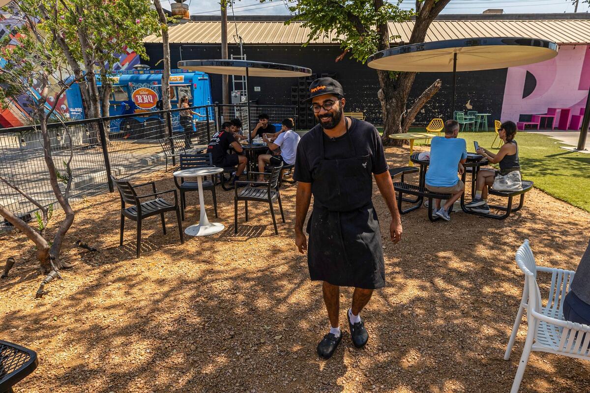 Zain Shafi, the owner of Sabar BBQ, walks around to check on customers and if they are happy with their food after service at the Sabar BBQ trailer parked at the corner of E Vickery Street and S Main Street near downtown Fort Worth on Saturday, Aug. 23, 2024. One of the reasons Shafi chose this spot was because he wanted to have an area for customers to eat and interact with.