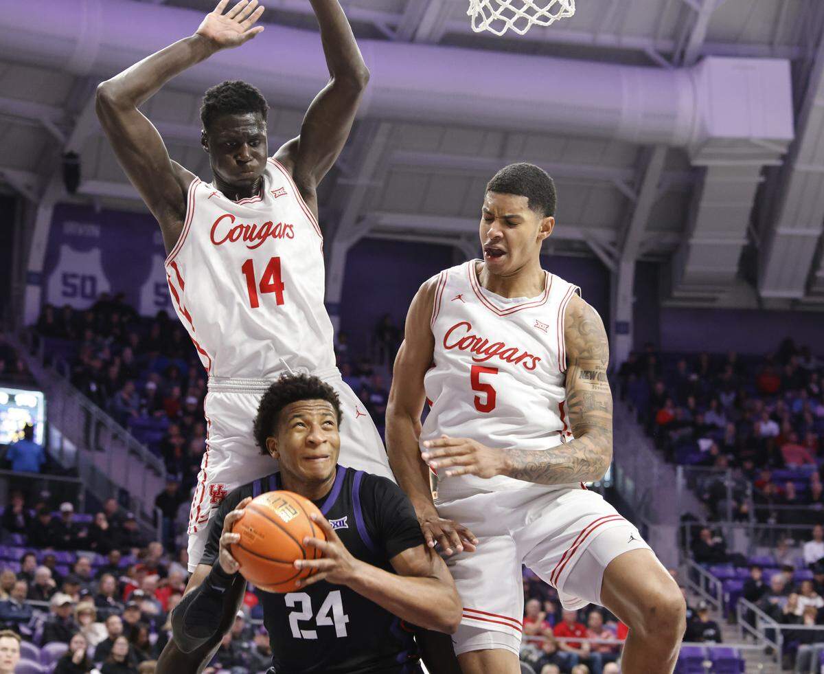 TCU forward Xavier Edmonds (24) attempts to get a shot under the net defended by Houston forwards Kalifa Sakho (14) and Chris Cenac Jr. (5) during the first half of a NCAA basketball game between the University of Houston and TCU at Schollmaier Arena in Fort Worth, Texas, Wednesday Jan. 26, 2026