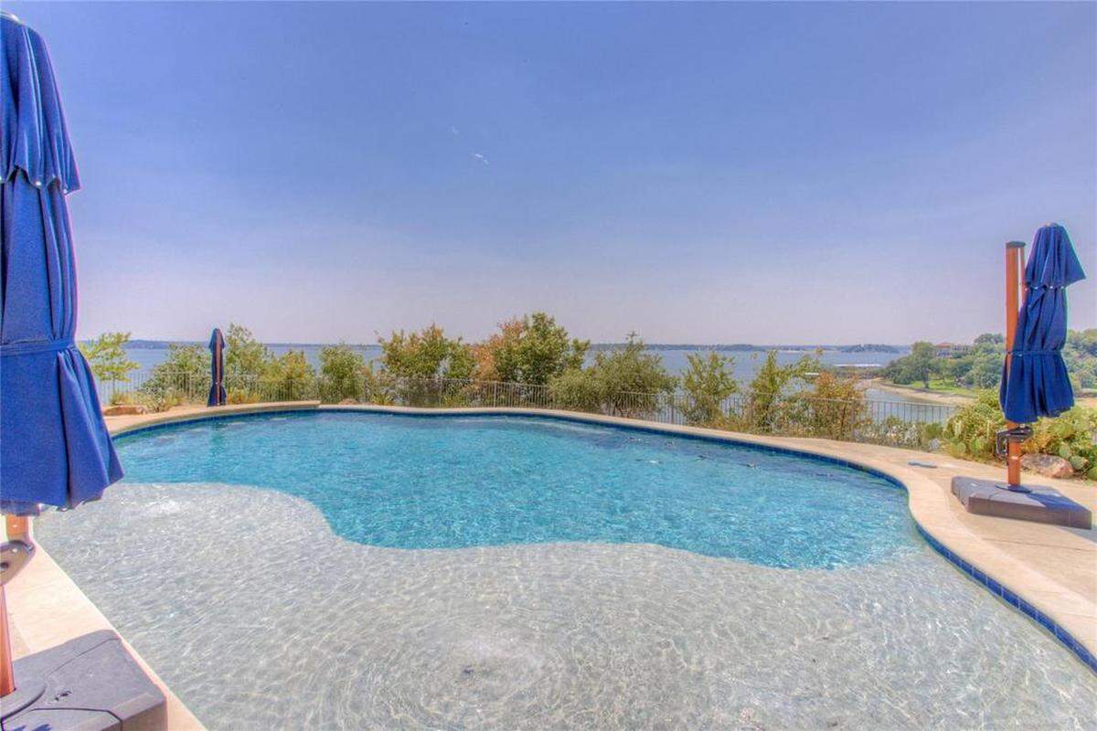 At the end of the home’s peninsula sits their in ground pool. To the right you can see sailing masts from the Fort Worth Boat Club.
