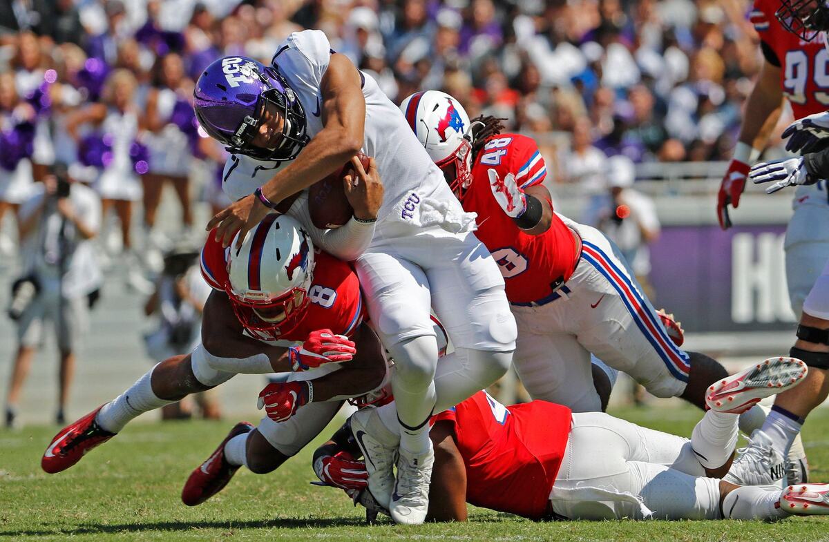 TCU Horned Frogs quarterback Kenny Hill (7) gets hit by SMU defenders while running the ball in the first quarter as TCU beats SMU 56-36 in their annual Iron Skillet game in Fort Worth, Saturday, September 16, 2017.