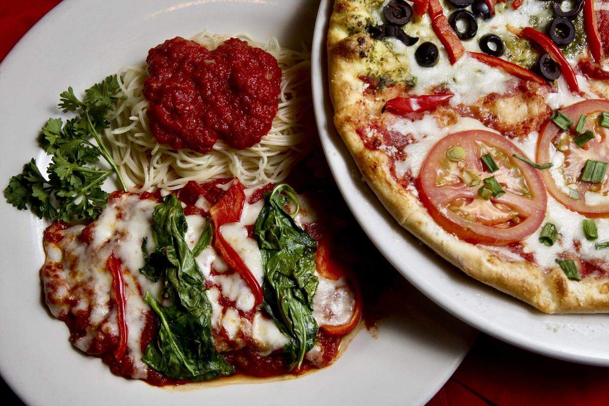 Eggplant parmigiana and a pizza with tomatoes, green onion, pesto, black olive, red peppers and Canadian bacon at Cafe Bella on November 16, 2011.