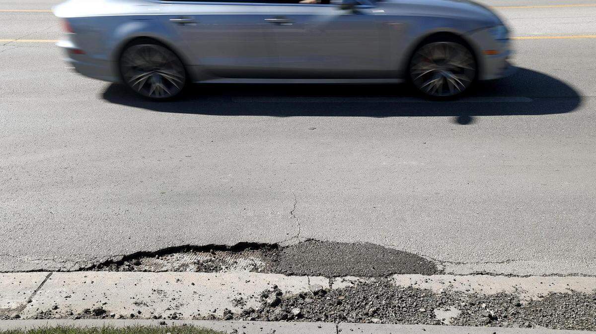 Vehicles pass potholes while driving north on 8th Street in Fort Worth on Tuesday, February 21, 2024.