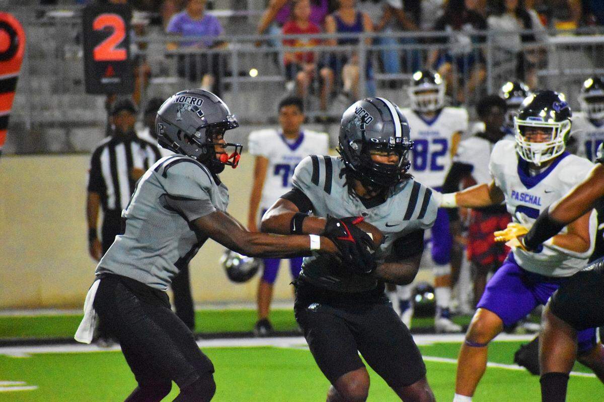 North Crowley’s Chris Jimerson hands the ball off to Ashton Searl in the second quarter of Friday’s game against Fort Worth Paschal at Crowley ISD Stadium.