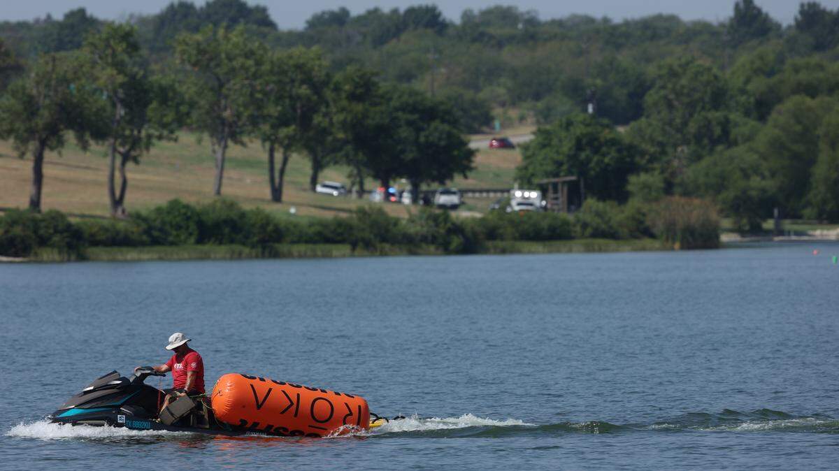 A jet ski pulls in buoys from the CrossFit Games at Marine Creek Lake in Fort Worth on Thursday morning, Aug. 8, 2024. The Fort Worth Fire Department responded to a call earlier in the morning about a possible drowning in the lake, where a swimming event for the CrossFit Games was being held.