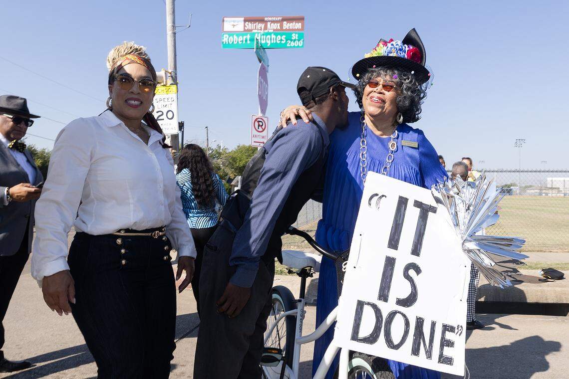 Former Dunbar principal Shirley Knox Benton is embraces by family next to her street topper during a dedication ceremony in her honor outside Dunbar High School in Fort Worth on Thursday, Oct. 2, 2025. The tribute highlights Benton's lasting impact on Dunbar and its role in the broader Fort Worth community.