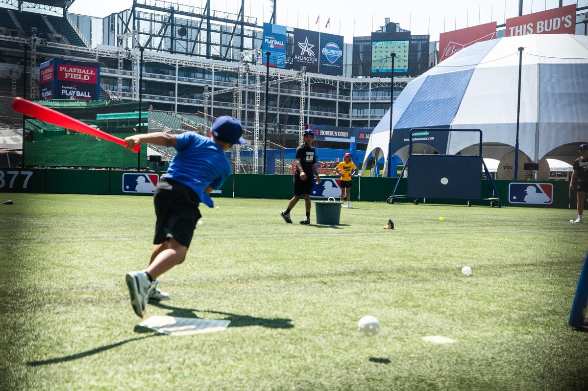 Eli Garcia, 9, swings the bat during the All-Star Village hard hat tour on Thursday, July 11 at the Choctaw stadium in Arlington. Fans are allowed to practice pitching and play a miniature baseball game with plastic bats and balls.