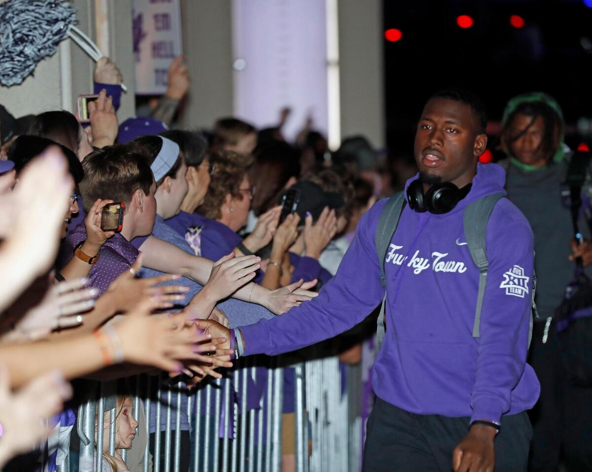 TCU safety Chace Biddle slaps hands with fans after returning home from the CFP national championship football game to the TCU Campus in Fort Worth, Texas, Tuesday, Jan. 10, 2023.
