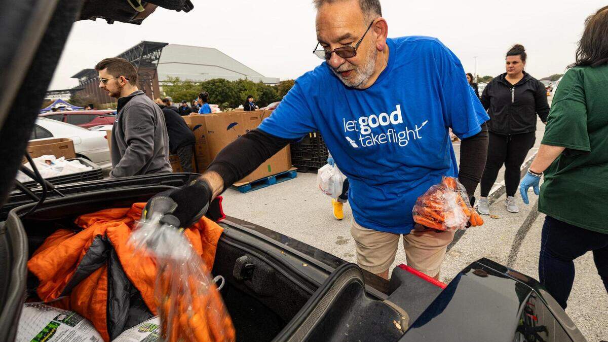 Orlando Velazquez puts various Thanksgiving groceries into the trunk of a car during the 4th annual Thanksgiving Mobile food distribution at AT&T Stadium in Arlington on Friday, November 17, 2023. The Tarrant Area Food Bank needs volunteers to staff its holiday food distributions.