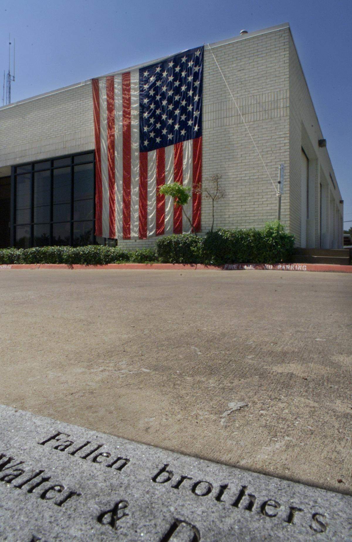 A large American flag is draped over the wall of the River Oaks Fire Department on Sept. 11, 2001. Firefighters decided to display the flag late Tuesday morning after the attacks on New York City and the Pentagon. A firefighter said the flag is in support of all the victims. River Oaks lost two firefighters in 1999 in a Lake Worth church blaze. The stone in the foreground is part of memorial to those firefighters and to another that was killed in 1964.