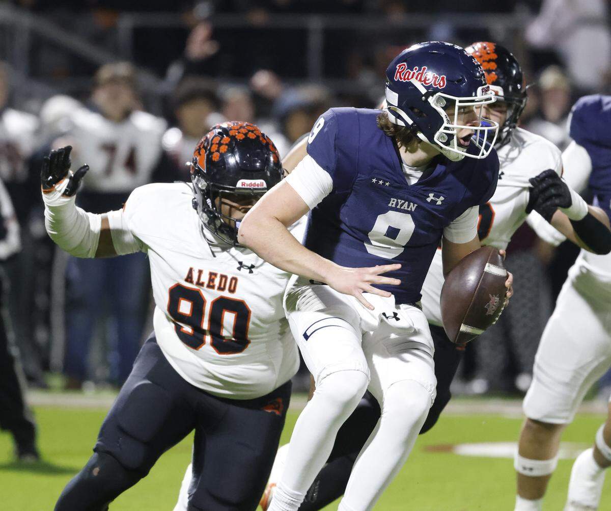 Aledo defensive tackle Tymon Meeks (90) and defensive end Cooper Cyphers (42) sack Denton Ryan quarterback Quin Henigan (9) for a loss during the first half of a UIL Class 5A Division I Quarterfinal on Friday Dec. 05, 2025 at Northwest ISD Stadium in Fort Worth, Texas.