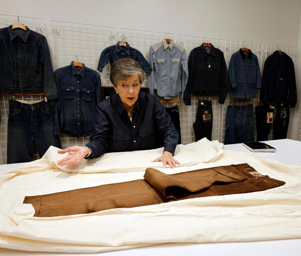 Archivist Ann Richardson talks about how a pair of pants were mineral dyed in the early years at Dickies offices in downtown Fort Worth Texas, Thursday Mar. 28, 2024. The pants from 1928 were never worn. The 102 year old work apparel company recently relocated to downtown Fort Worth. (Special to the Star-Telegram Bob Booth)