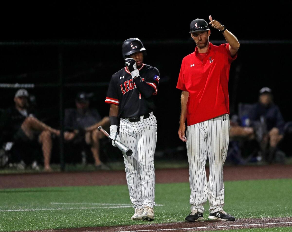 Legacy head coach Christopher McMullen coaches up right fielder Connor Crayton (17) as a new Aledo pitcher warms up during game one of a 5A Region I final baseball game at Cleburne High School, Texas, Friday, June 03, 2022. Legacy defeated Aledo 8-5 in the first game of a best of three series. (Special to the Star-Telegram Bob Booth)