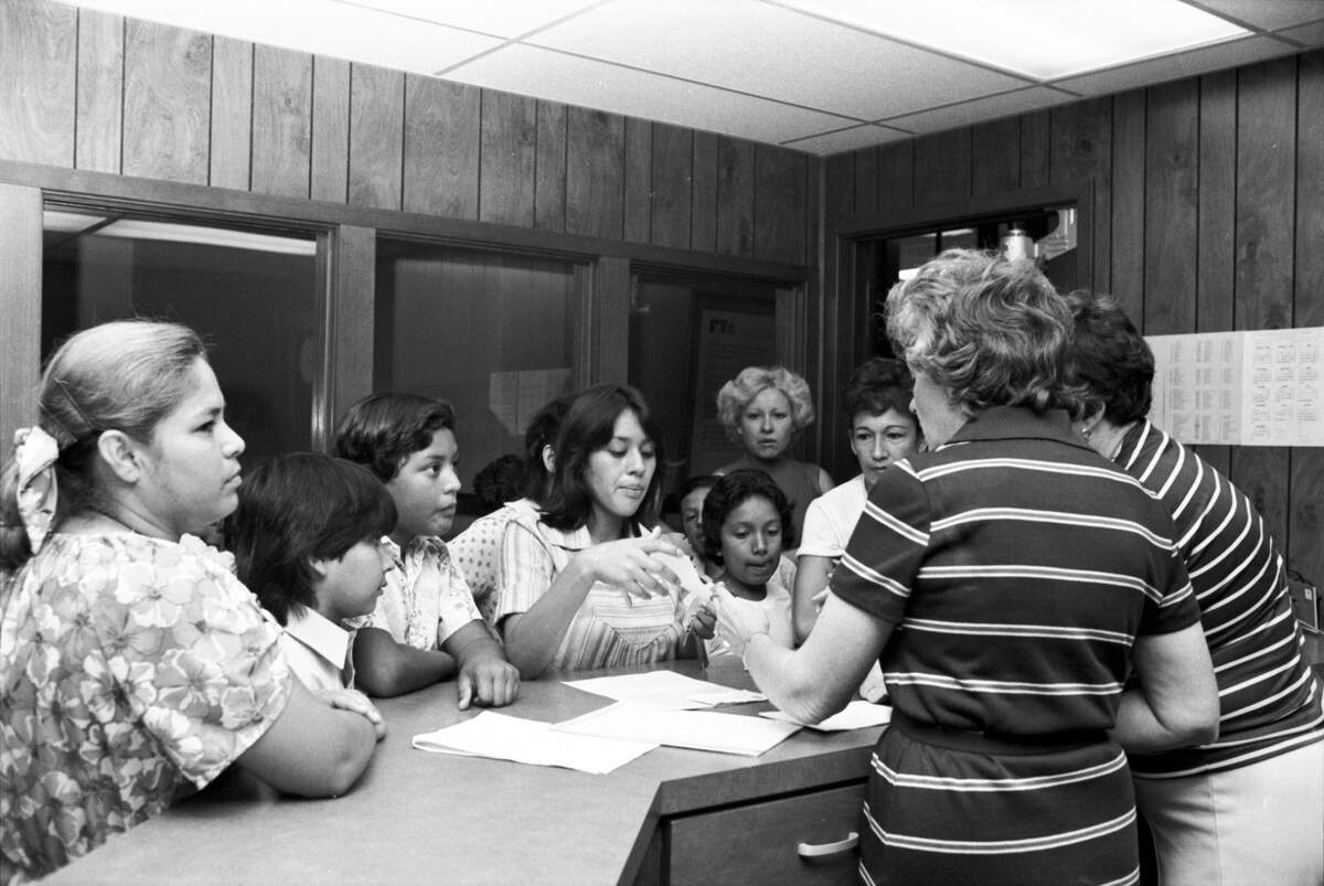 Sept. 5, 1980: Non-citizens are seen in the office of Denver Avenue Elementary (since renamed Rufino Mendoza Sr. Elementary) in Fort Worth with their children on the first day of school. Children of non-citizens were able to register for school as a result of a July 1980 federal court ruling that they cannot be excluded from Texas schools or forced to pay tuition. The court concluded that education was a state function and should be provided to all.