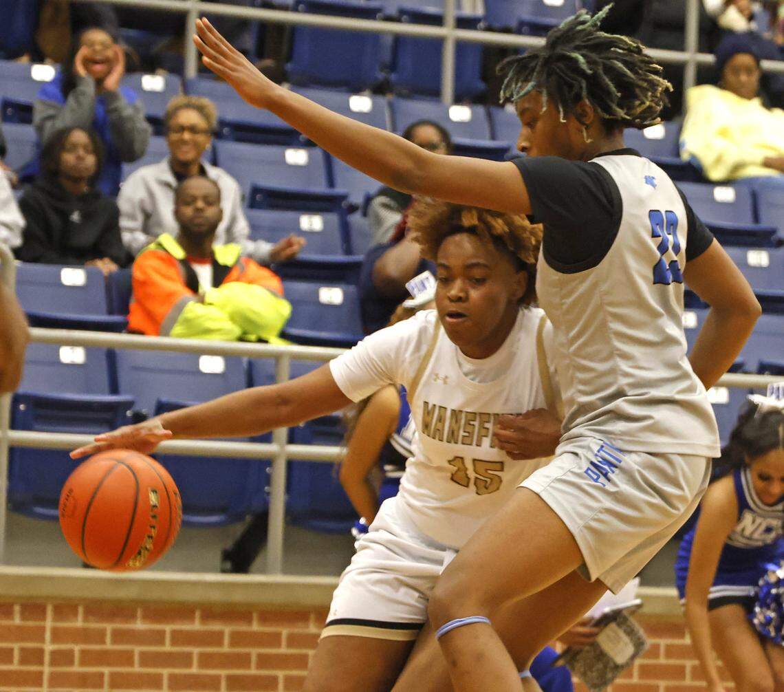 Mansfield shooting forward J'nye Weaver (15) drives in hard to North Crowley forward Mecca Crawford (23) during the first half of a UIL girls basketball game between North Crowley and Mansfield at Mansfield High School in Mansfield, Texas, Tuesday Jan. 20, 2026