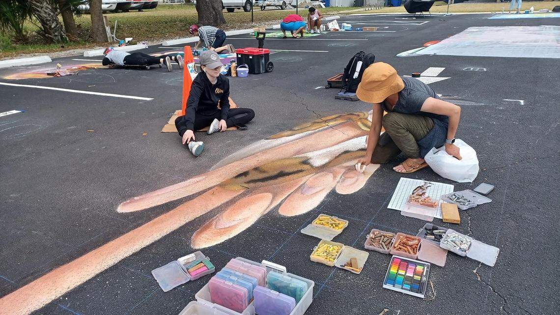 Jan Riggins and her daughter Olivia work together on a chalk art project. Riggins has become well-known throughout the Metroplex for her art, which brightens the looks of sidewalks, driveways and other pedestrian areas.