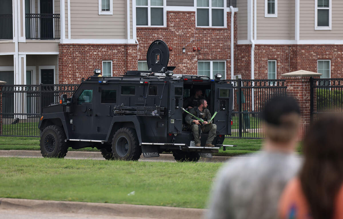 An armored police vehicle moves down North Riverside Drive on Tuesday, April 28, 2026. Police said that while a civilian employee was investigating a burglary call in the area, a man began shooting and the employee was injured.