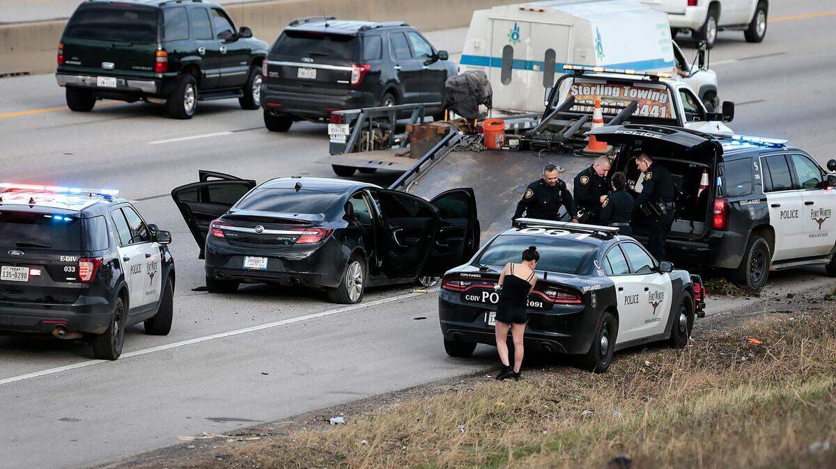 Members of the Fort Worth Police Department work to remove a vehicle involved in a standoff on Interstate 30 near Sandy Lane in East Fort Worth on Monday, January 7, 2019.