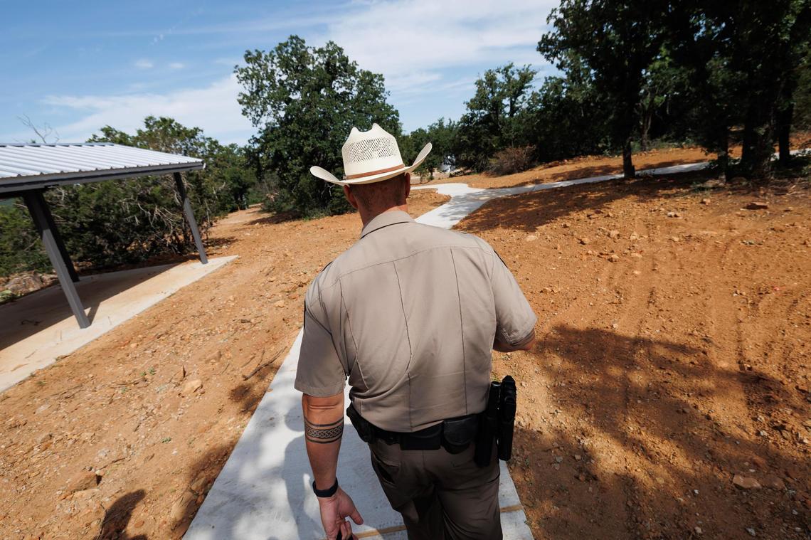 Palo Pinto Mountains State Park Park Superintendent James Adams walks along a sidewalk to leads to a completed pavilion overlooking the lake on May 21.