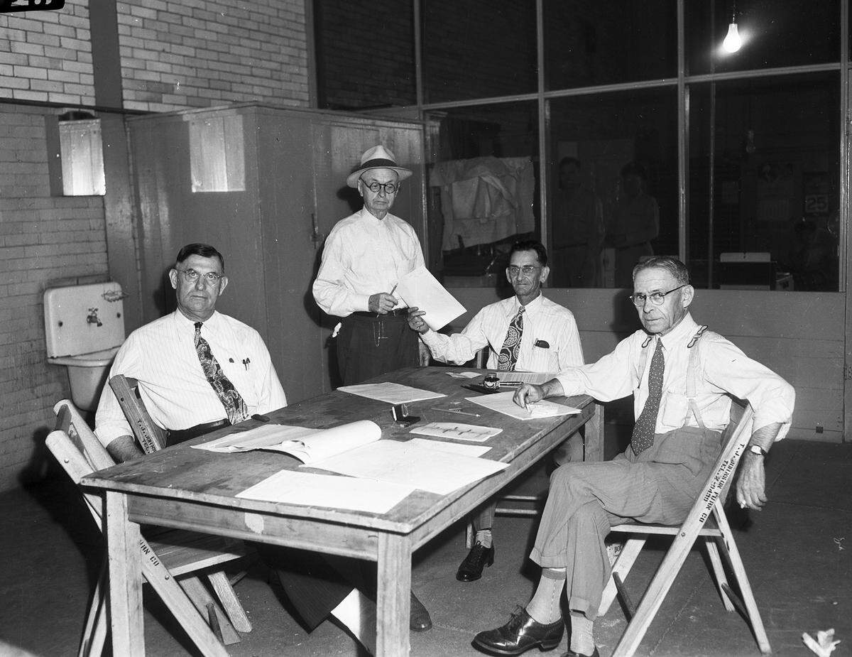 Aug. 25, 1945: Voting turnout is light for the constitutional amendments election. A mid-morning scene at Precinct 3 shows the small turnout. One lone voter, I.N. Snow, is standing and receiving his ballot. Seated, left to right, are election judges A.H. Johnson, El L. Davis, and Leon Friedman.
