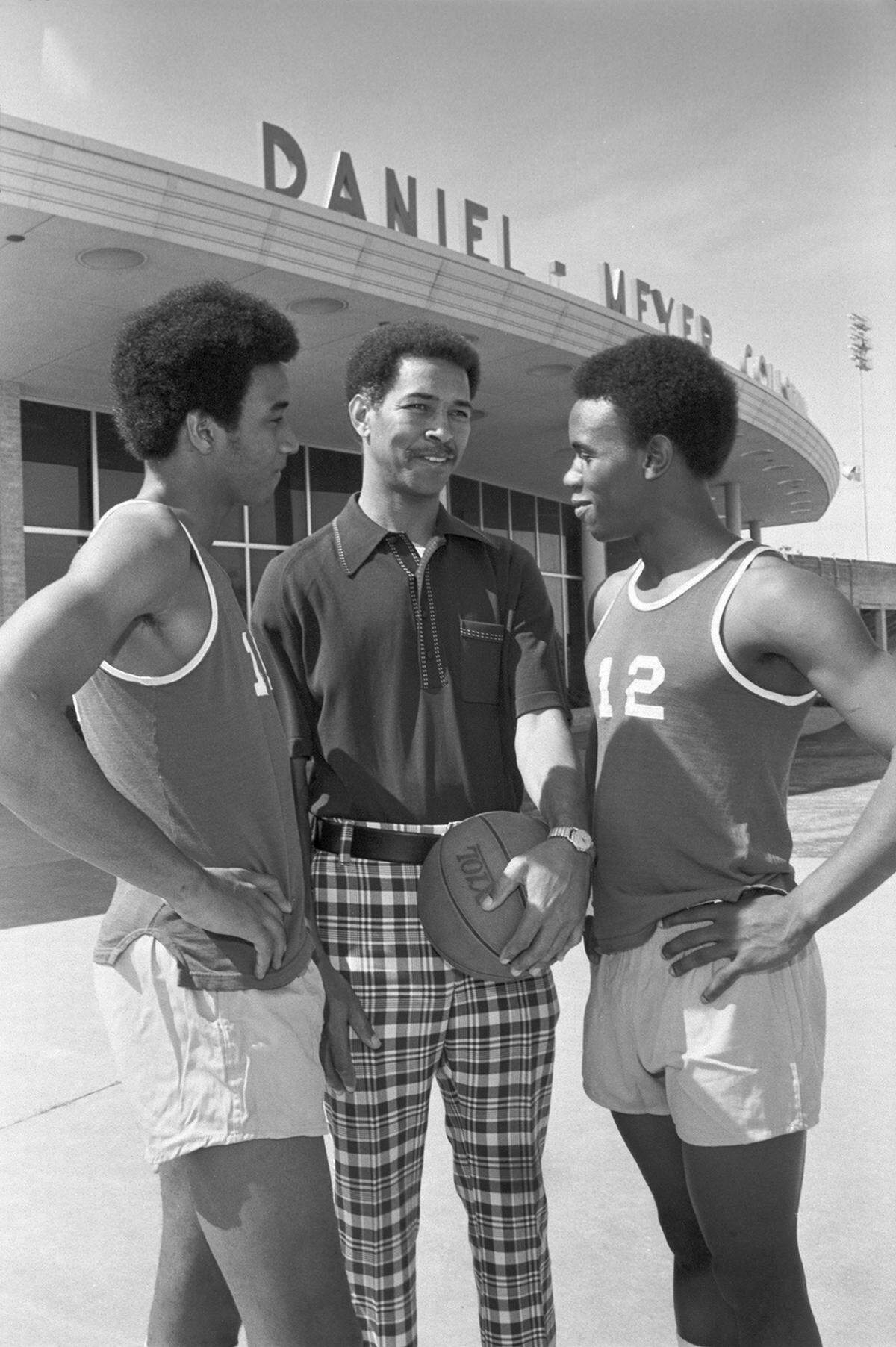 Robert Hughes, Dunbar High School basketball coach, and two of his players, seniors Grady Marshall, left, and Ricky McCain, pose outside of the Daniel-Meyer Coliseum prior to a workout. Daniel-Meyer will host the city championship basketball game between Dunbar and Southwest High Schools.