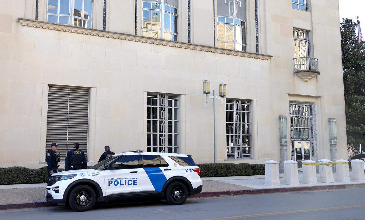 Law enforcement agents stand outside the federal courthouse in downtown Fort Worth on Monday, Feb. 23, 2026. A second attempt of the trial of nine defendants indicted in connection to the nonfatal shooting of a police officer outside a North Texas ICE detention center last year began Monday.