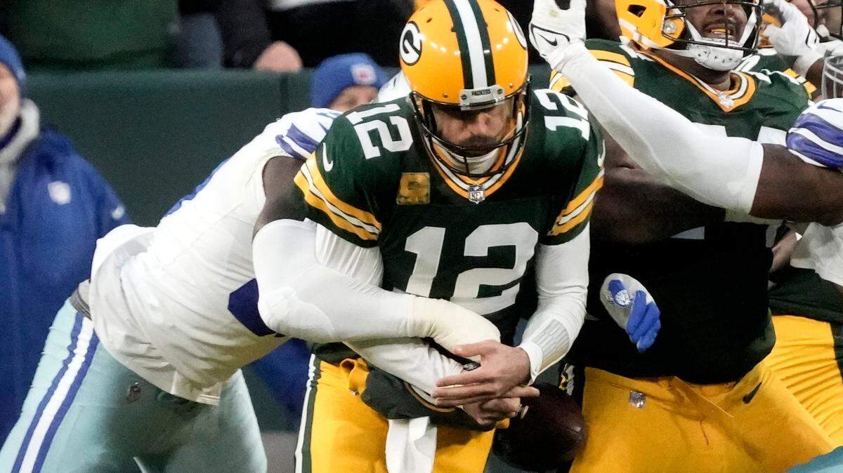 Green Bay Packers quarterback Aaron Rodgers (12) fumbles the ball after being sacked by Dallas Cowboys defensive end DeMarcus Lawrence, left, during the first half of their game Sunday at Lambeau Field.