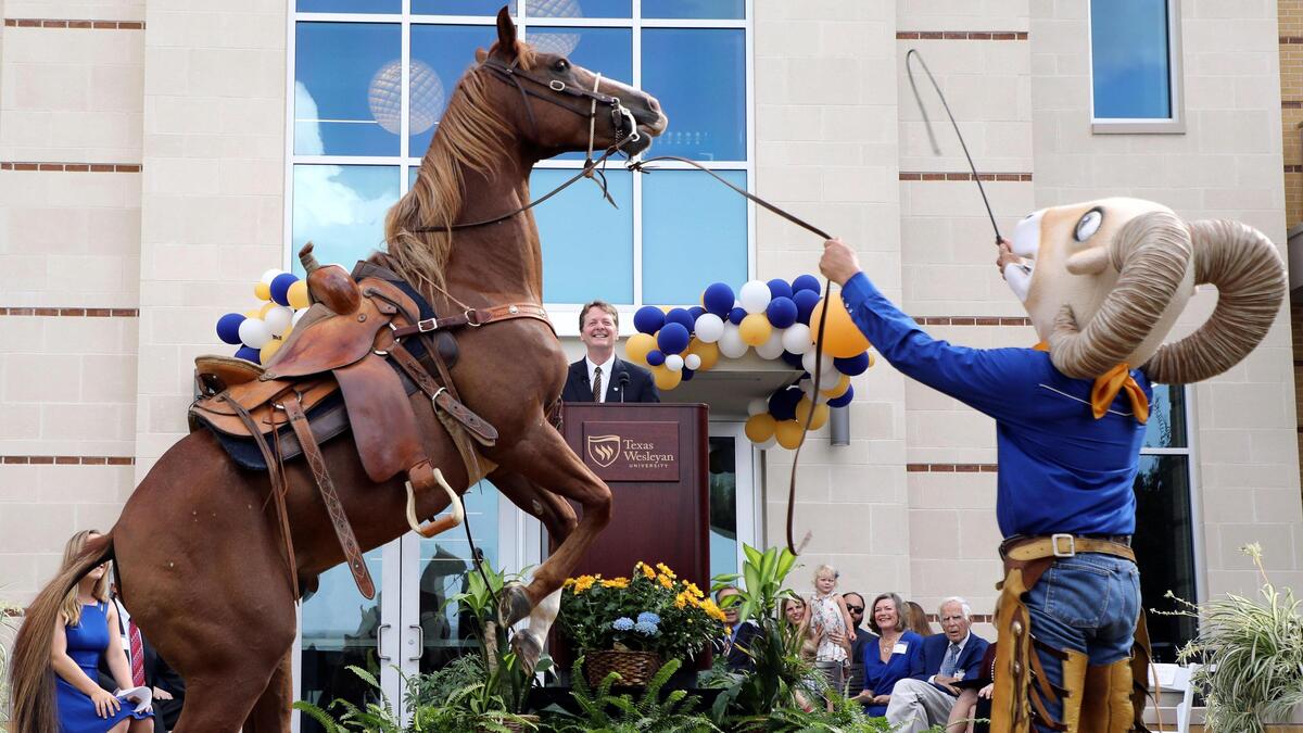 Gus stands on one hoof under the direction of Texas Wesleyan University mascot Willie during the ribbon-cutting for the Nick and Lou Martin University Center in Fort Worth on Tuesday. The building will house student lounge spaces, admissions office, bookstore and dining options.