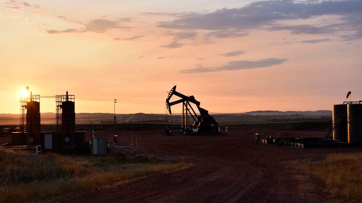 FILE - An oil well works at sunrise Aug. 25, 2021, in Watford City, N.D., part of McKenzie County. The Biden administration on Friday, Nov. 26, called for an overhaul of the nation’s oil and gas leasing program to focus on areas that are most suitable for energy development and raise costs for energy companies to drill on public lands and water. (AP Photo/Matthew Brown, File)