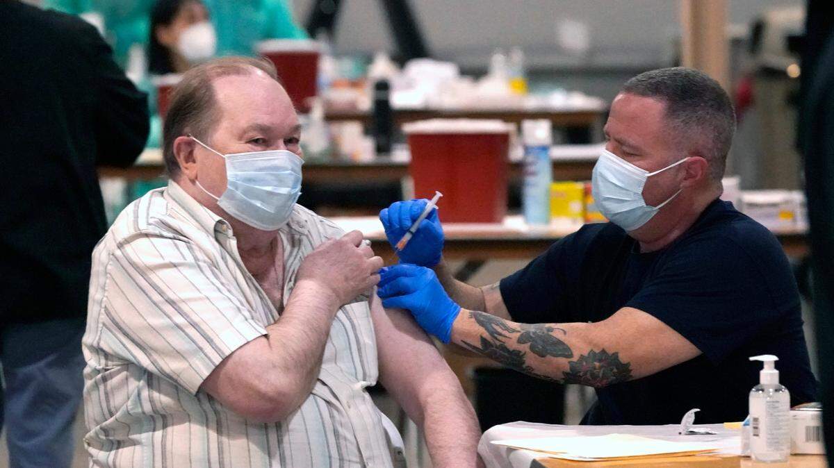 Howard Holland, 82, receives his first dose of the COVID-19 vaccine from Wes Vaughn at the Dallas County mass vaccination site at Fair Park on Wednesday, Jan. 20, 2021, in Dallas.