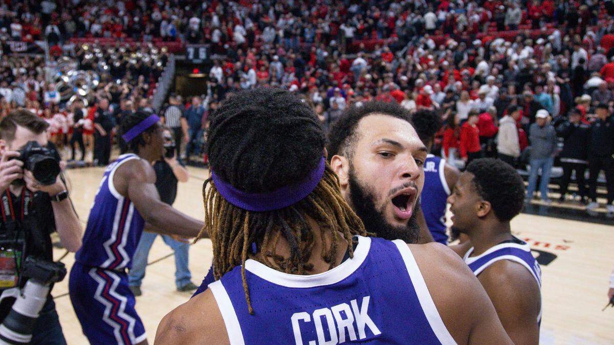 TCU’s Xavier Cork (12) and JaKobe Coles (21) celebrate a win over Texas Tech after an NCAA college basketball game on Saturday.