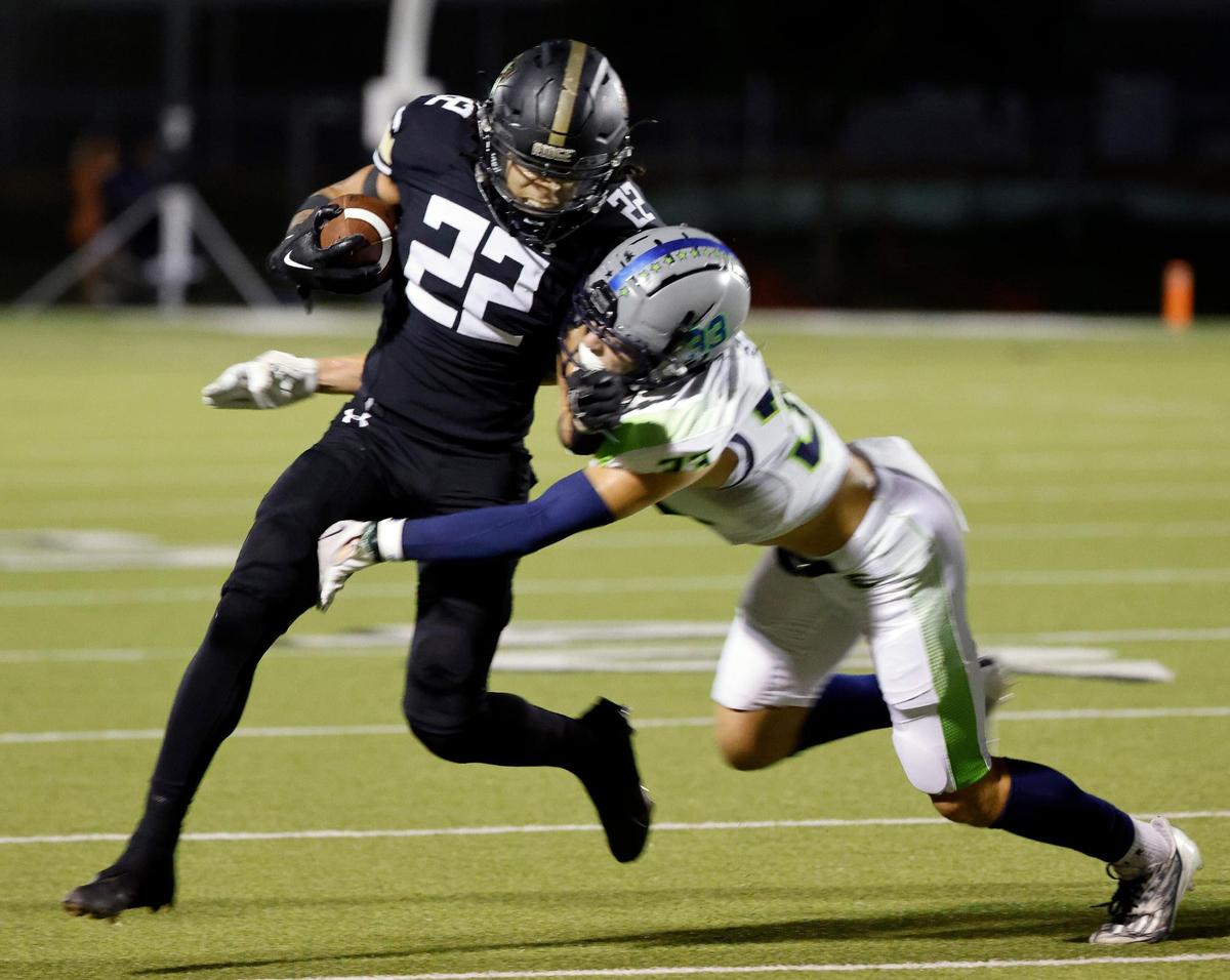 Keller Fossil Ridge running back Cameron Moran (22) attempts to avoid the tackle by Haslet Eaton safety Ben Self (33) in the first half of a UIL high school football game at Keller ISD Stadium in Keller, Texas, Thursday, Sept. 21, 2023. Eaton led 24-14 at the half.