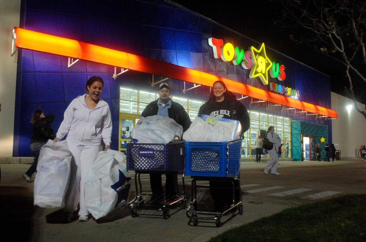 Nov. 23, 2007: Black Friday shoppers Nicole Fore (left), Justin Shields and his sister Jackie Shields leave Toys R Us with bags of Christmas shopping in Hurst.