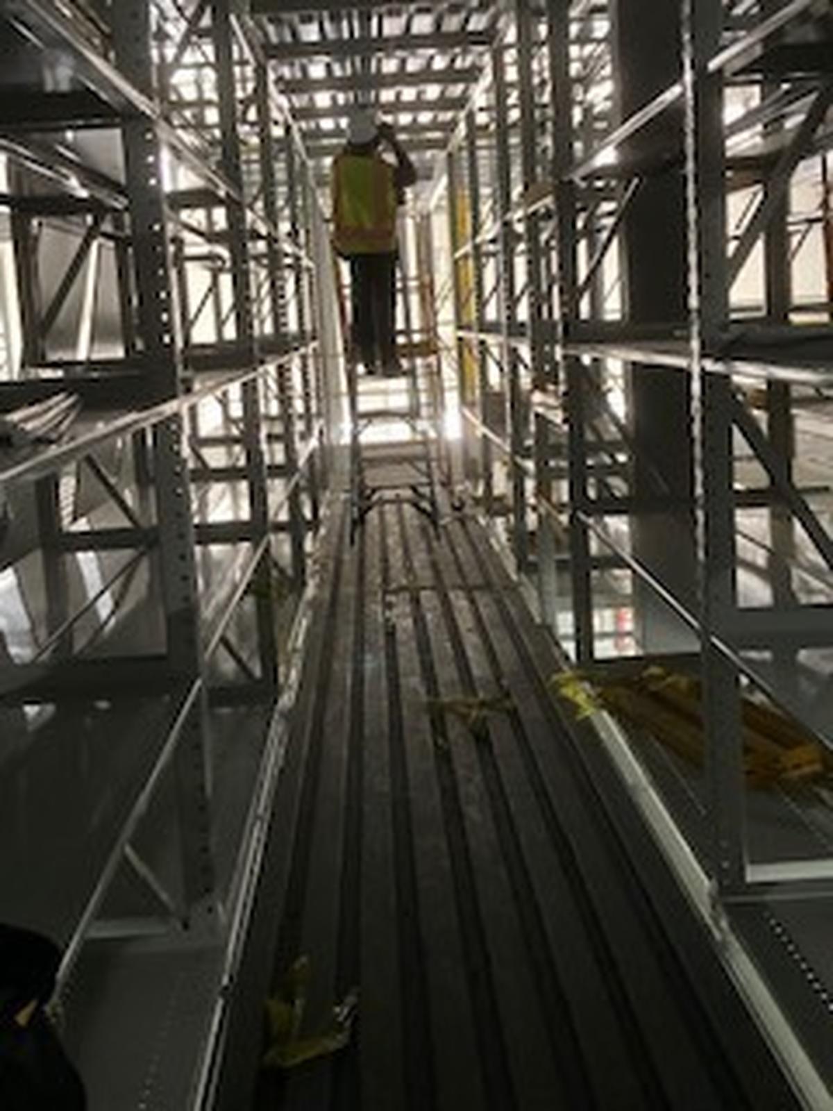 A construction workers stands on an A-frame ladder placed on a corrugated metal deck in this photo from a former safety manager. Ladders must have a flat surface, says former safety manager and whistleblower at Fort Worth Amazon fulfillment center construction site.