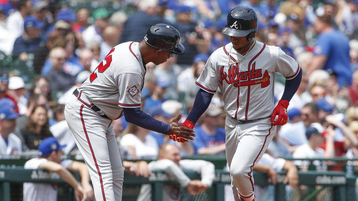 Ron Washington, left, has taken over coaching the Braves' infielders, and their overall defense has improved. One beneficiary is All-Star second baseman Ozzie Albies, right.