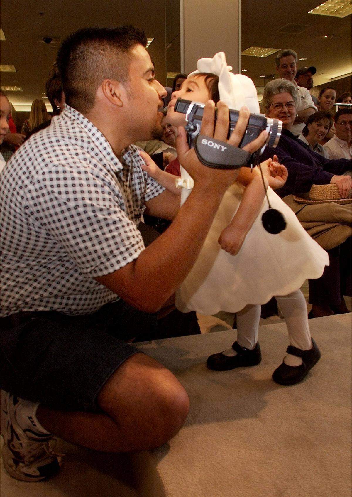 Aug. 25, 2001: Ninteen-month-old Reyna Ramirez kisses her dad Steve, as she reaches the end of the catwalk at the Fall Children's Fashion Show at Neiman Marcus at Ridgmar Mall in Fort Worth.